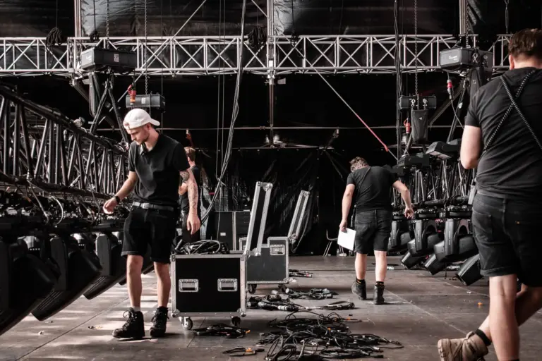 Lighting crew working on the mainstage floor during load-in at Lux Expo festival