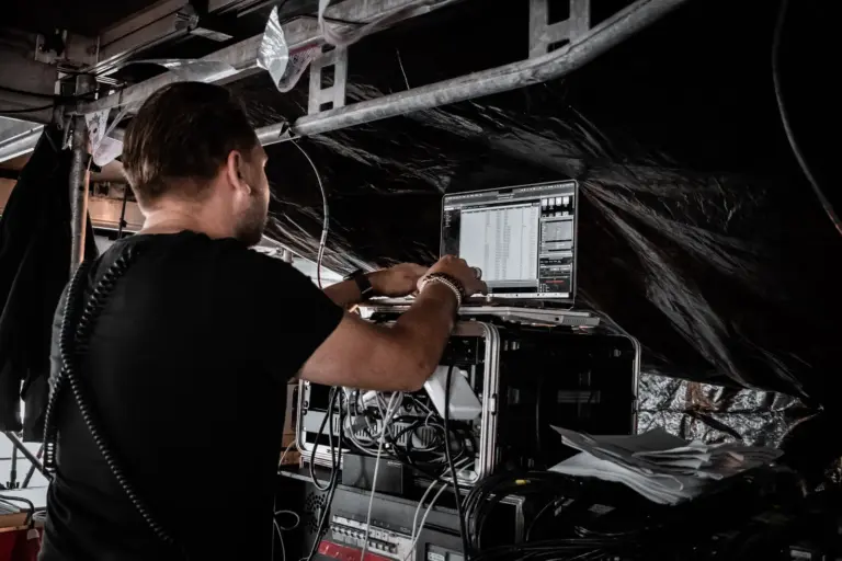 Lighting technician checking the patch and an incoming artist show file on-site at Lux Expo