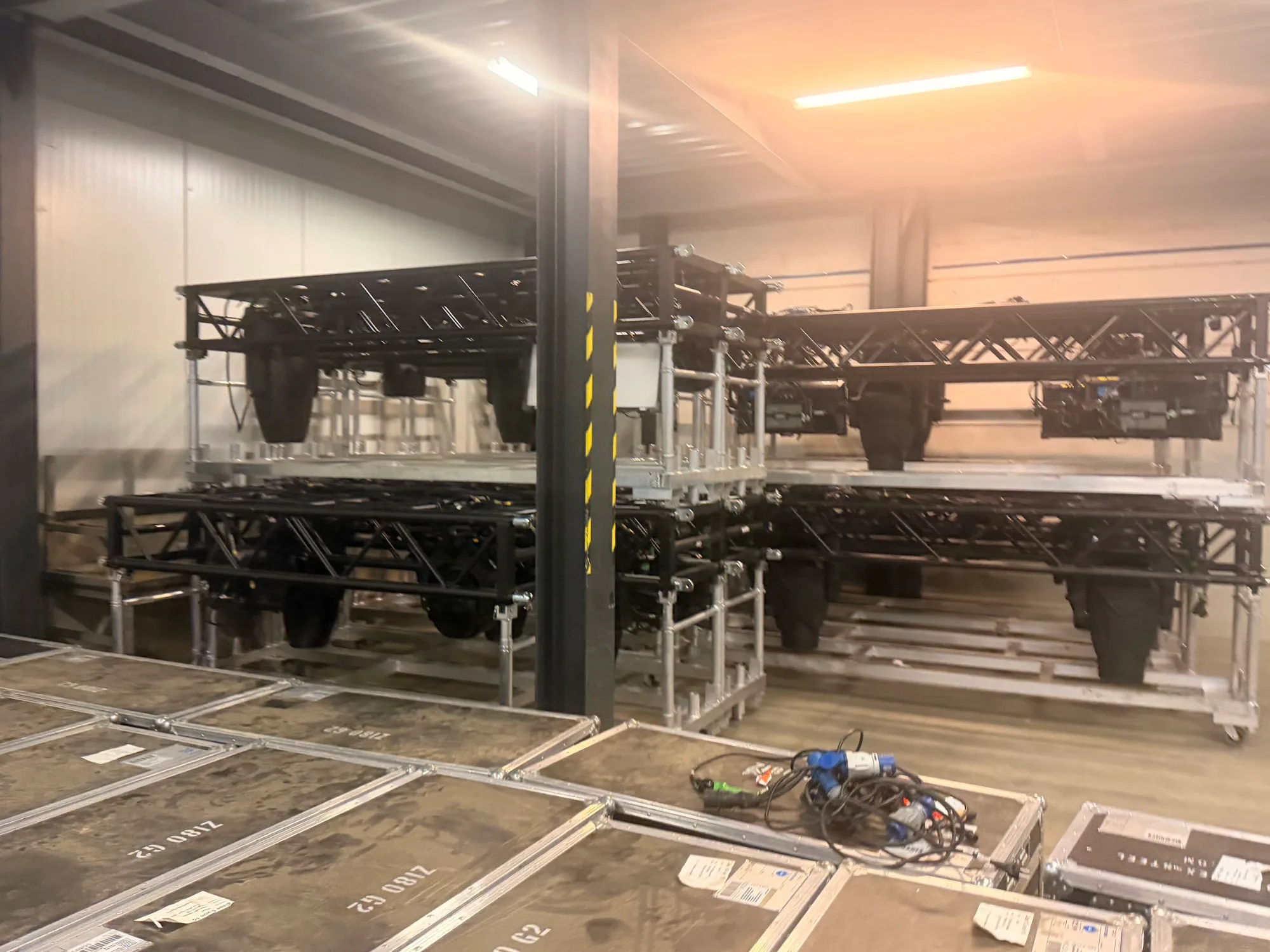 Pre-rigged tour trusses with moving heads lined up in the warehouse for MagicCon 2026